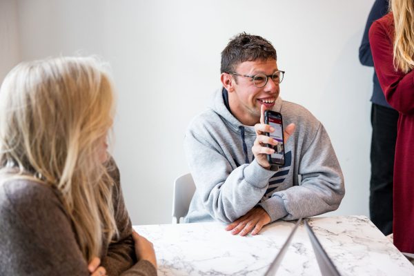 Customer smiling holding up phone 