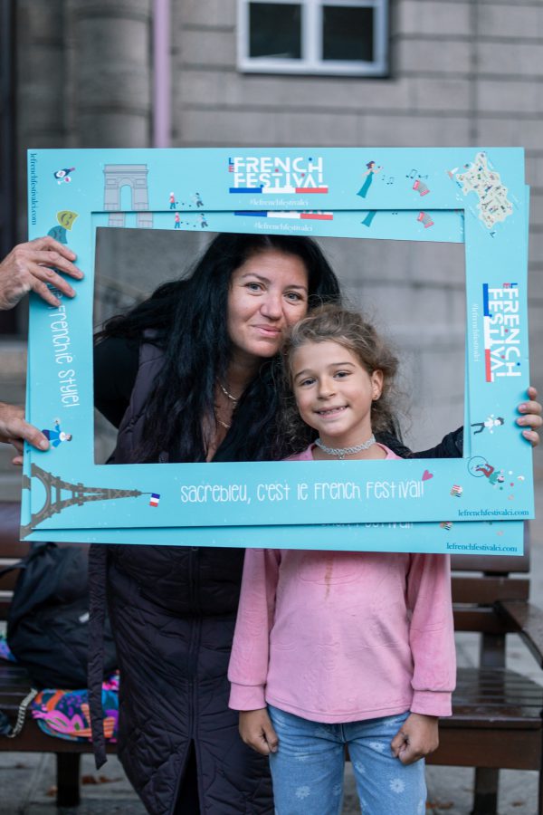A mother and daughter taking a picture within a photo frame