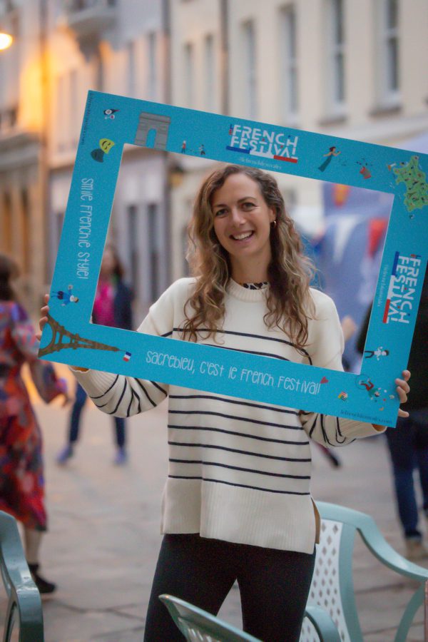 A woman taking a picture within a photo frame